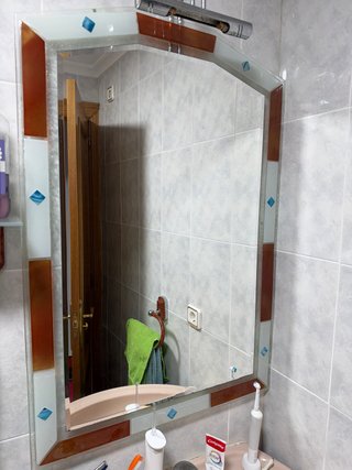 Espejo de baño con detalles decorativos, sin luz.