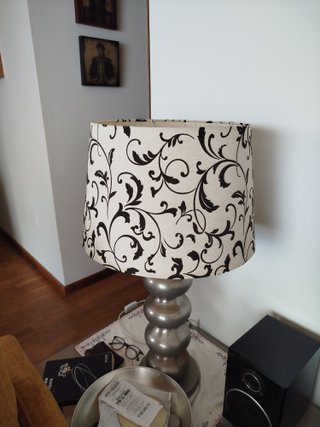 Lámpara de mesa alta con pie plateado y tulipa.