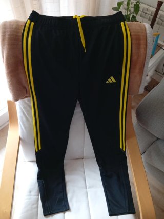 Pantalón de chándal Adidas negro y amarillo.