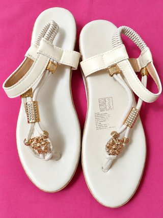 Sandalias blancas con detalles decorativos dorados