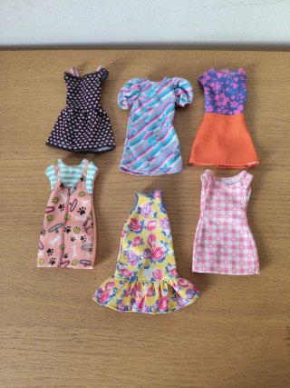 Set di sei vestiti vari per bambola Barbie, con diversi motivi e colori.