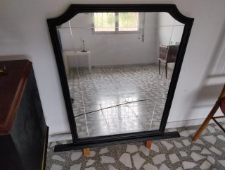 Espejo antiguo con marco de madera negro.