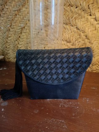Bolso de mano negro con solapa trenzada