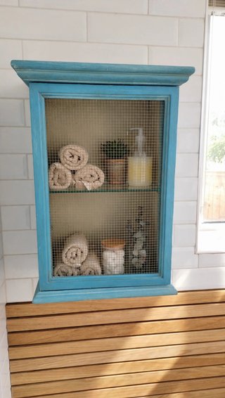Mueble de baño azul con puerta de rejilla