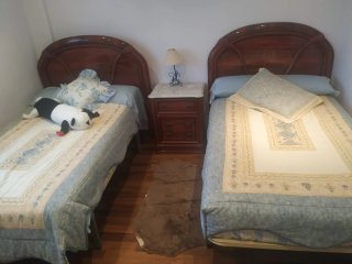 Dormitorio con 2 camas y mesita