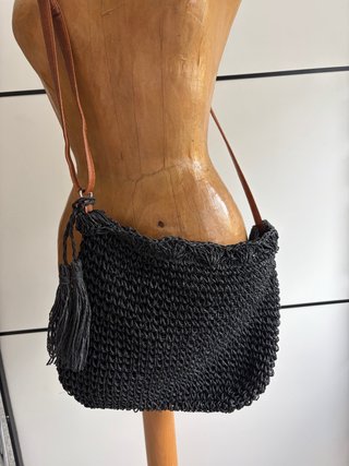 Bolso de mano negro con detalle de borla