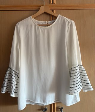 Blusa blanca con mangas acampanadas