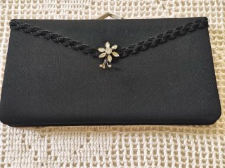 Cartera de mano negra con broche