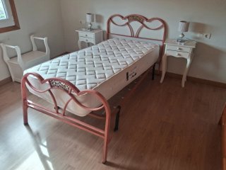 Cama individual con mesillas y lámparas