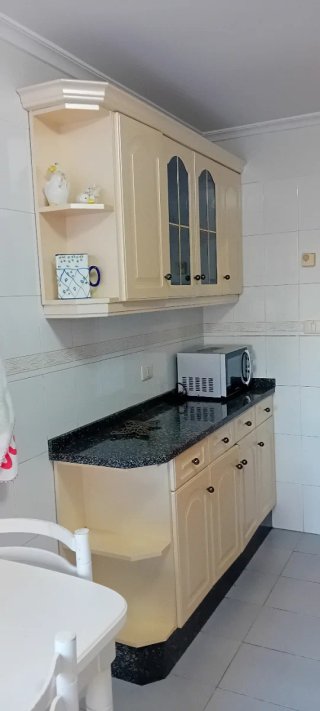 Muebles de cocina beige y encimera negra