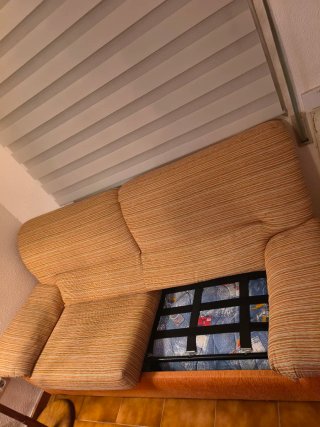 Sofá cama de tela naranja.