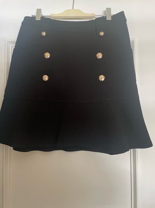 Falda corta negra con botones dorados