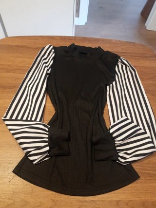 Camisa de punto negra con mangas a rayas de satén.
