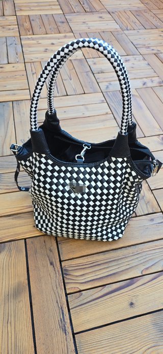 Bolso de mano estampado damero blanco y negro.