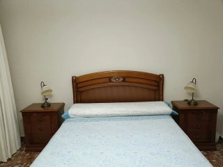 Dormitorio de madera con 2 mesitas y cabecero.