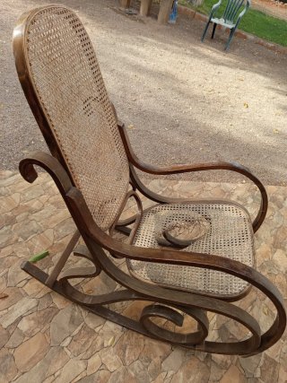 Silla mecedora de madera y mimbre.