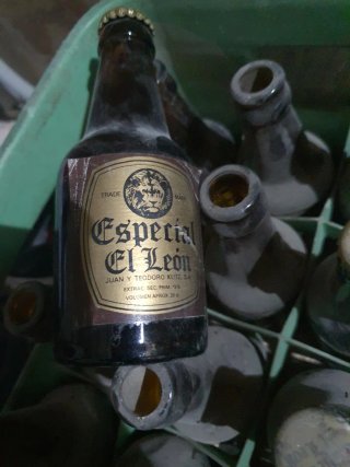 Botellones pieni e vuoti e scatola di birra Especial