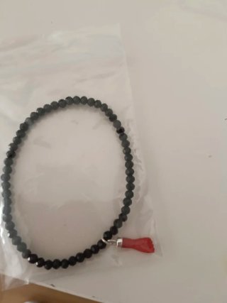 Pulsera de cuentas negras con amuleto rojo