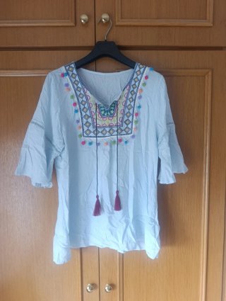 Camiseta azul con bordados y pompones