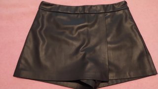 Falda pantalón de piel negra y camisa.
