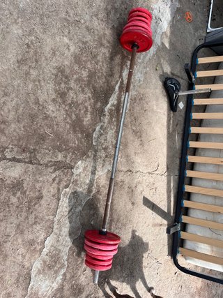 Barra de pesas con discos rojos