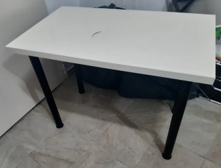 Mesa color blanco y patas negras.