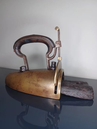 Antigua plancha de latón con lingote de hierro