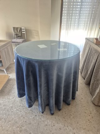 Mesa camilla con cristal y faldillas azules.
