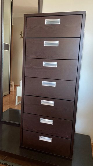 Cómoda alta de madera marrón con espejo.