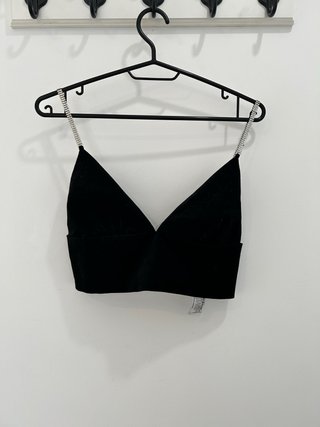 Top de fiesta negro con tirantes brillantes.
