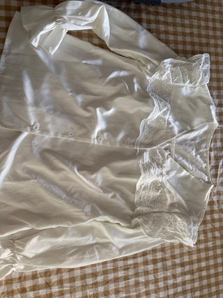 Blusa blanca con detalles de encaje y abullonada