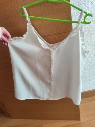 Blusa blanca sin mangas con volantes
