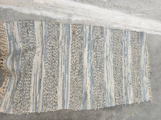 Alfombra juvenil de tela con diseño a rayas azul.