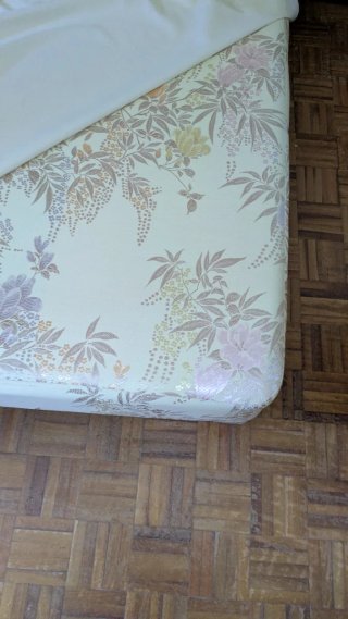 Base tapizada beige con motivos florales.