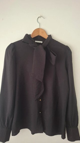 Blusa negra con lazo al cuello de El Corte Inglés