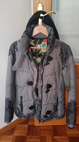 Abrigo acolchado gris con detalles.
