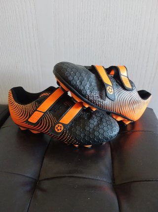 Botas de fútbol infantiles negras y naranjas