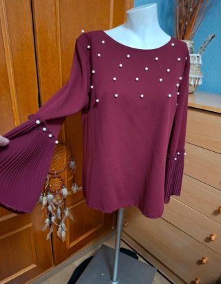 Blusa vaporosa con mangas plisadas y perlas