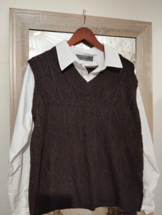 Chaleco de punto marrón con camisa blanca
