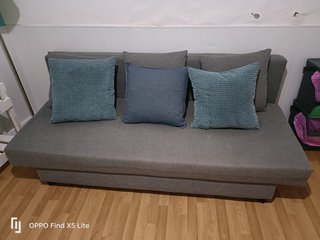 Sofá cama gris con cojines