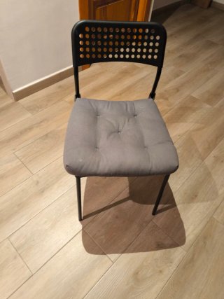 Silla con estructura negra y cojín gris