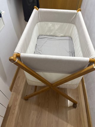 Cuna de bebé con estructura de madera y ruedas