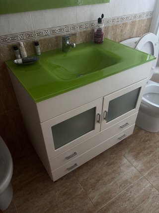 Mueble de baño blanco con lavabo verde