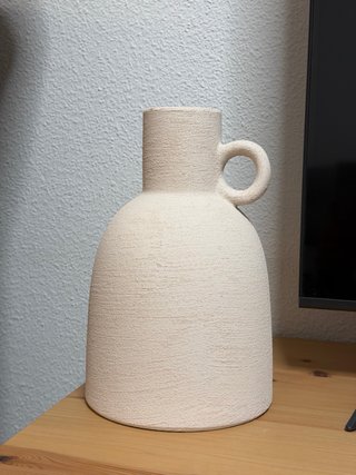 Jarrón de cerámica blanco roto.