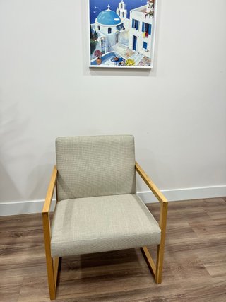 Sillón de tela beige con estructura de madera