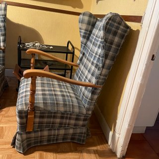 Sillón orejero de cuadros y brazos de madera